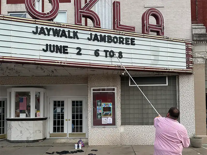 photo of someone putting letters on the Okla theater marquee